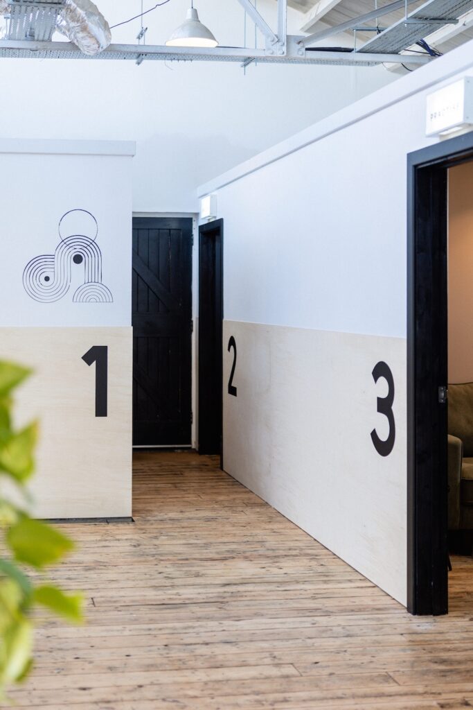 The picture shows a bright hallway with three doors